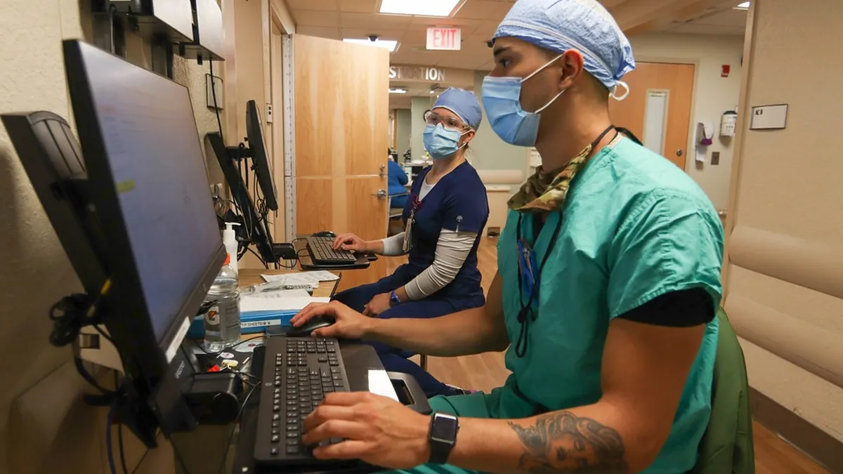 Doctor reviewing patient records on a computer between consultations